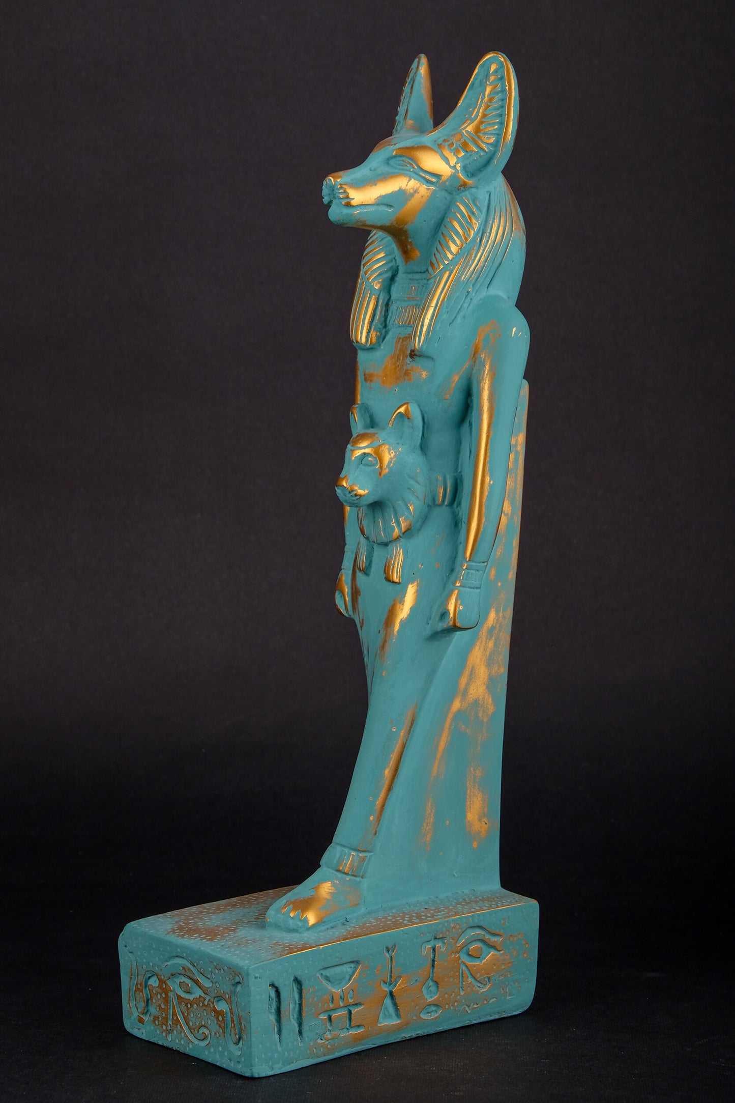 Ancient Egyptian statue of Anubis Jackal symbol of afterlife and mummification, with front a head of Sekhmet green goldish color