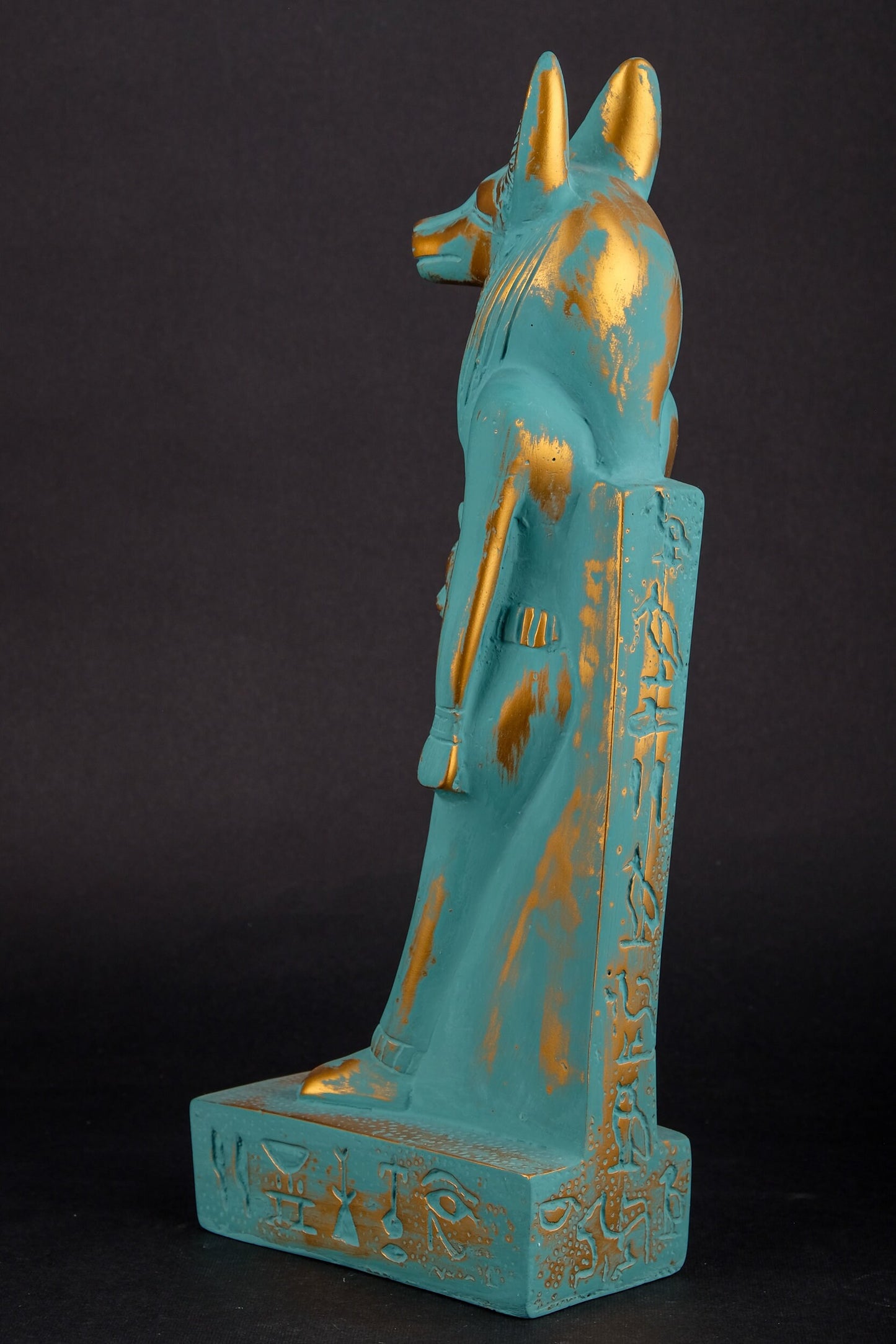 Ancient Egyptian statue of Anubis Jackal symbol of afterlife and mummification, with front a head of Sekhmet green goldish color