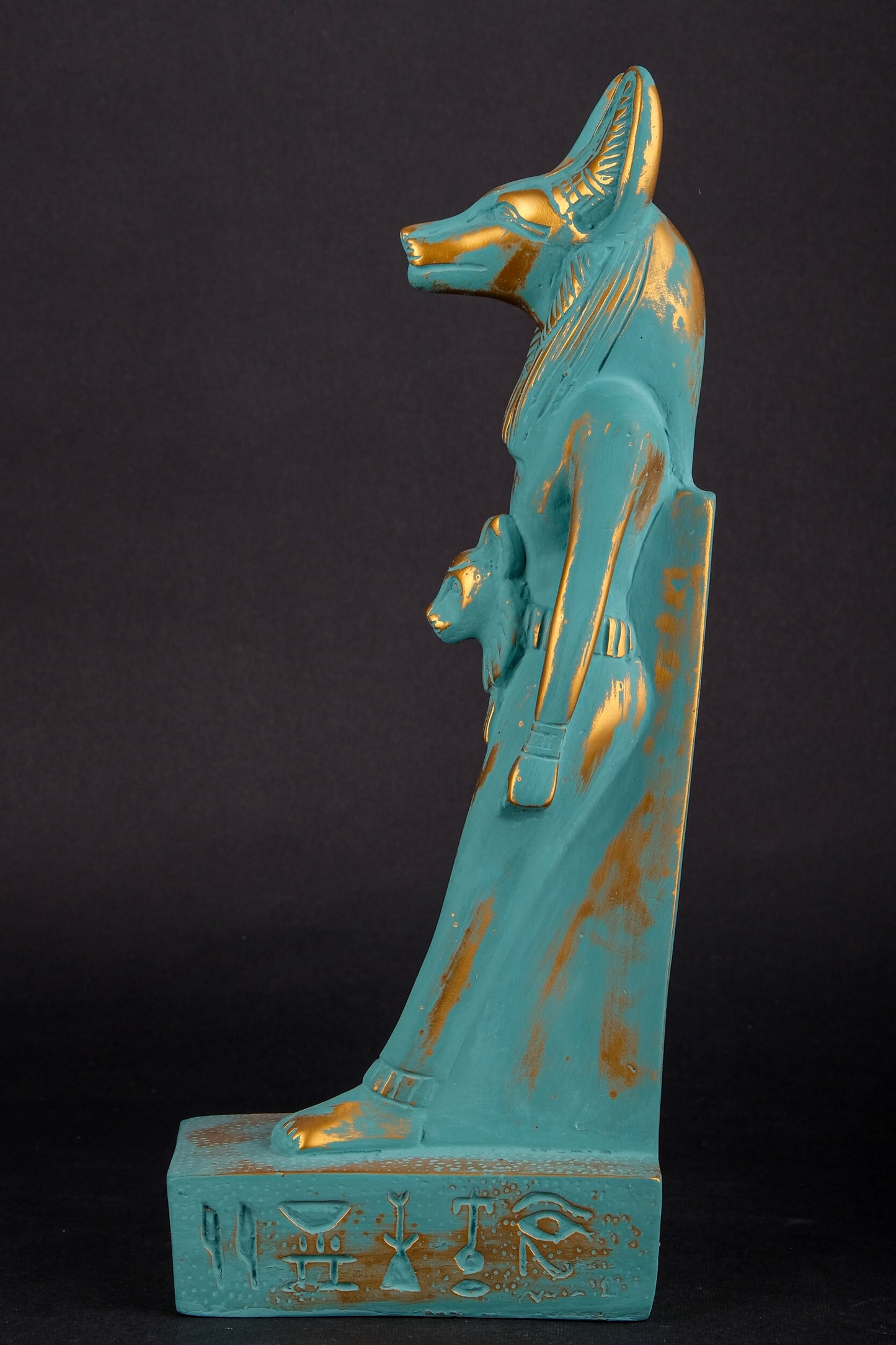 Ancient Egyptian statue of Anubis Jackal symbol of afterlife and mummification, with front a head of Sekhmet green goldish color