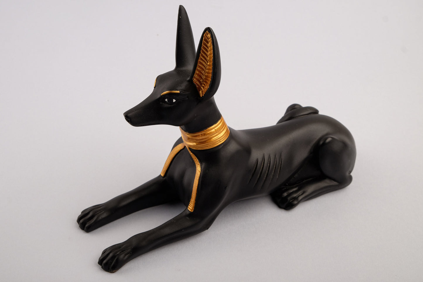 A unique ancient Egyptian statue of Anubis Jackal God of afterlife and mummification, stone black and gold painted made in Egypt