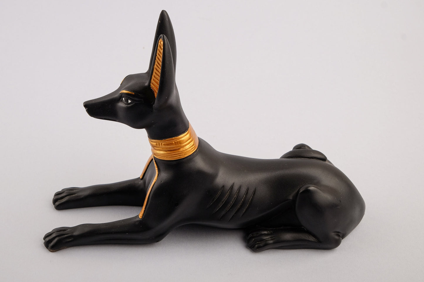 A unique ancient Egyptian statue of Anubis Jackal God of afterlife and mummification, stone black and gold painted made in Egypt