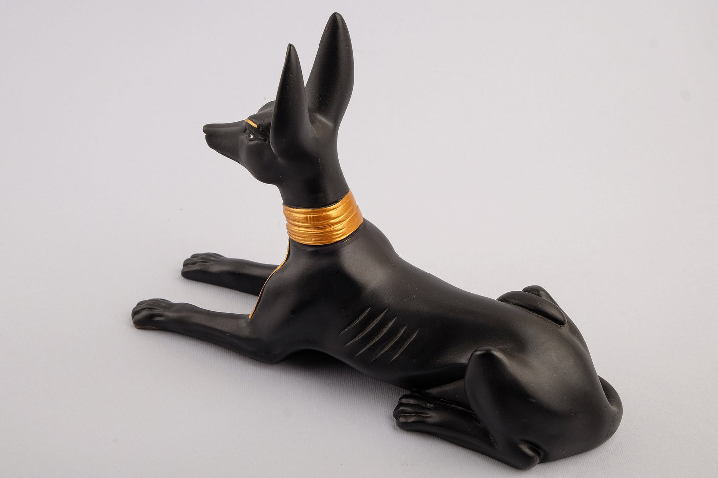 A unique ancient Egyptian statue of Anubis Jackal God of afterlife and mummification, stone black and gold painted made in Egypt