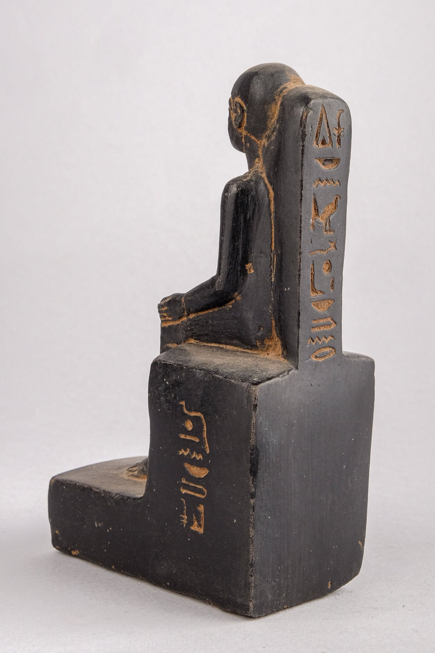 Statue of Egyptian Art seated statue of Imhotep holding an open papyrus scroll heavy black stone made in Egypt.