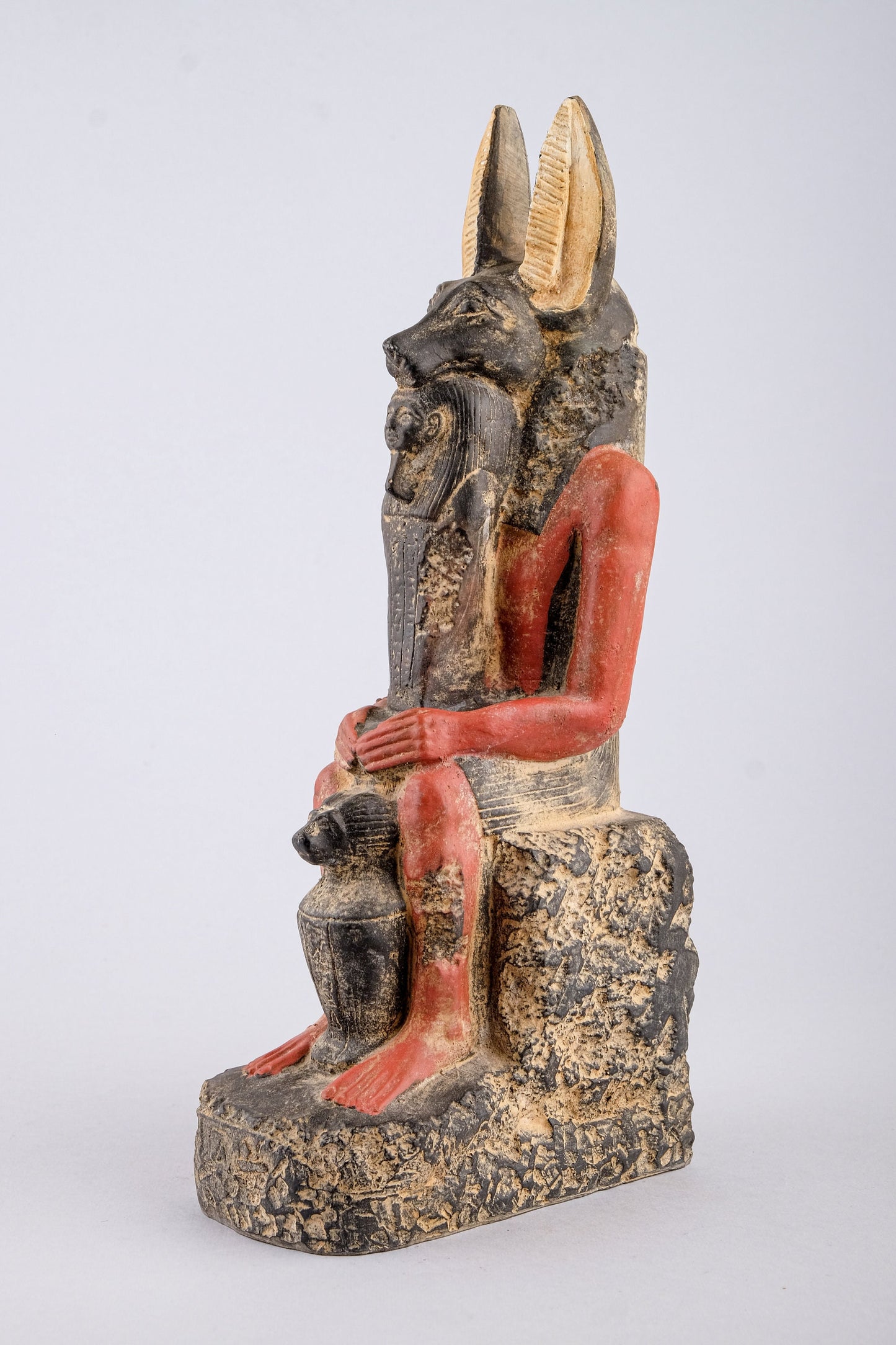 Seated Anubis Jackal holding a mummy form with a Hapi (Son of Horus) resting between his legs heavy stone handcrafted made in Egypt